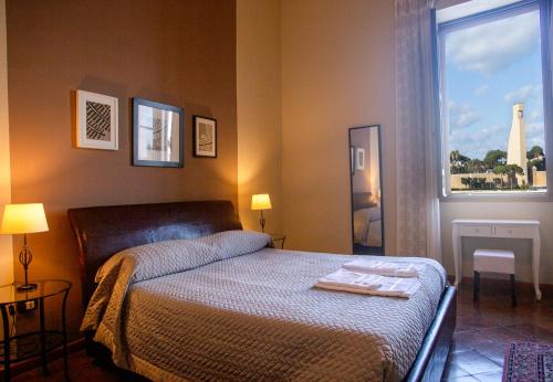 Un dormitorio con una cama y una ventana con una torre en B&B Regina Margherita, en Brindisi