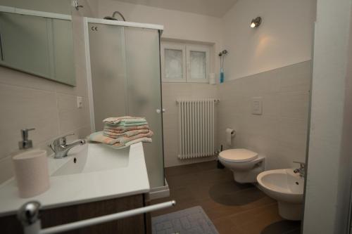 Baño blanco con lavabo y aseo en Entire apartments with stunning view, en Cademario