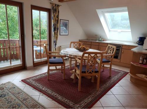 a kitchen with a table and chairs in a room at Wanderoase Ibental in Asbach