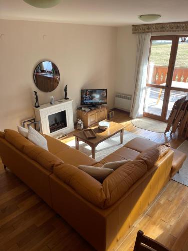 a living room with a couch and a tv at Allure in Pirin Golf in Razlog