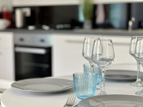 un groupe de verres à vin et de assiettes sur un comptoir de cuisine dans l'établissement NEYT parking, à Annecy