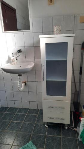 a bathroom with a sink and a white cabinet at Apartman Radovic in Pale