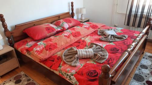 a bed with a red comforter and pillows on it at Apartman Radovic in Pale