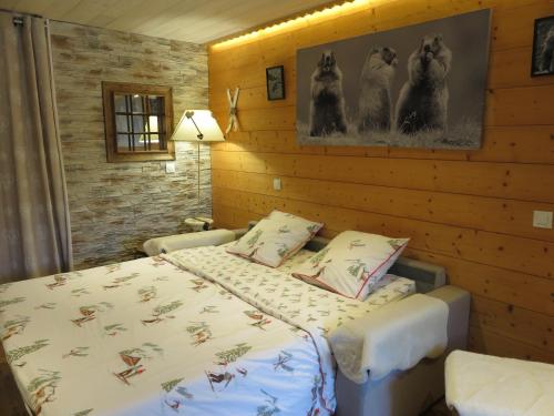 a bedroom with two beds in a room with wooden walls at Pensée Des Alpes 2 Etoiles Ski and Spa in Brides-les-Bains