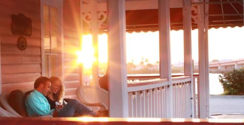 a couple sitting on the porch of a house at The Riverview Hotel - New Smyrna Beach in New Smyrna Beach
