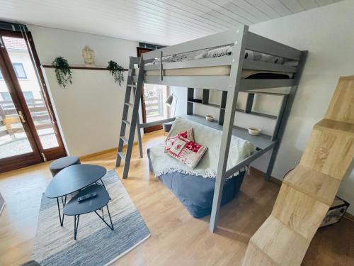 梅塔比耶的住宿－Au Doubs Village，客房设有双层床、桌子和椅子。