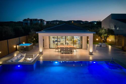 a backyard with a table and a pool at night at Villa Fabiana in Kipseli