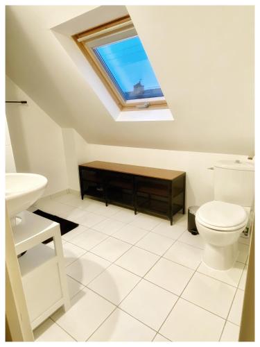 La salle de bains est pourvue de toilettes et d'une lucarne. dans l'établissement Mille Sabords, au Guilvinec