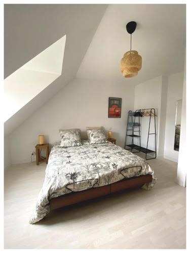 une chambre avec un grand lit dans un grenier dans l'établissement Mille Sabords, au Guilvinec