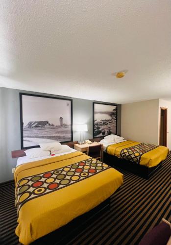 a hotel room with two beds with yellow sheets at Super 8 by Wyndham Humboldt in Humboldt