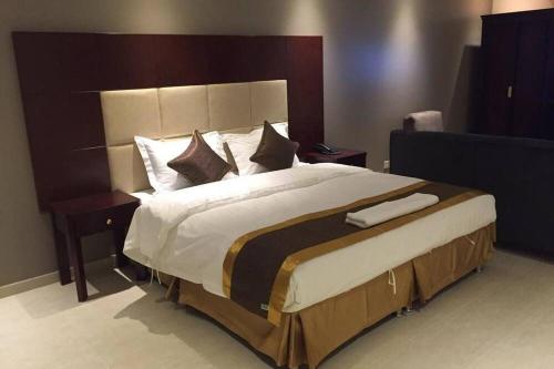 um quarto com uma cama grande e uma grande cabeceira. em تأجير شهري وسنوي em Al Khobar
