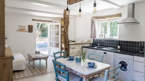 une cuisine avec une table et des chaises dans une pièce dans l'établissement La Cour Souveraine - Gîte Omaha, à Mosles