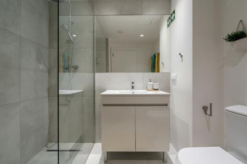a bathroom with a sink and a glass shower at Apartamento Centro de Albufeira Sunny in Albufeira