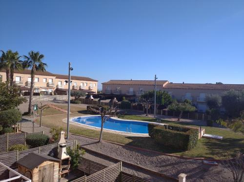 um resort com piscina e alguns edifícios em Fantástica casa con piscina y playa ,Torredembarra-Tarragona em Pobla de Montornés