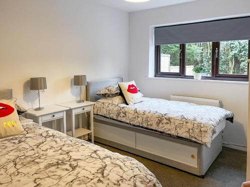 1 dormitorio con 2 camas y ventana en Devonshire Nook, en Chinley