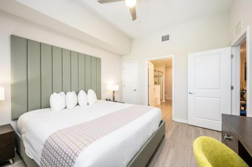 a bedroom with a large white bed and two chairs at Brand New Modern Vista Cay Reserve Condo - 5003 in Orlando