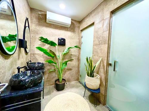 baño con lavabo, espejo y planta en Imperial Resort Hurghada en Hurghada