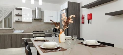 una cucina con tavolo e vaso di fiori di Modern, spacious and bright apt in centre of Malta a Mosta