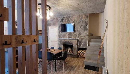 ein Wohnzimmer mit einem Tisch und einem Kamin in der Unterkunft Greenfield Bakuriani in Bakuriani