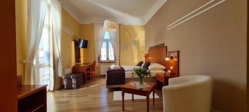Habitación de hotel con cama y sala de estar. en Pension Elektra en Mariánské Lázně