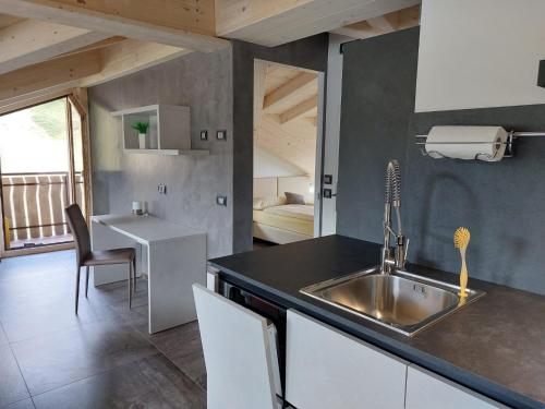 a kitchen with a sink and a counter with a table at Lucas Haus in Livigno