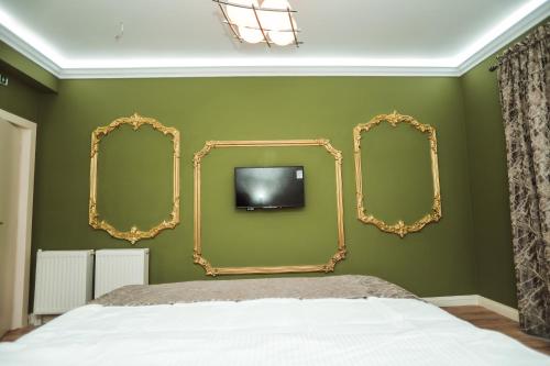 1 dormitorio con 2 espejos y TV en la pared en Rezidenca Medi Nako, en Korçë