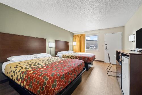 a hotel room with two beds and a television at Bend Inn & Suites in Bend