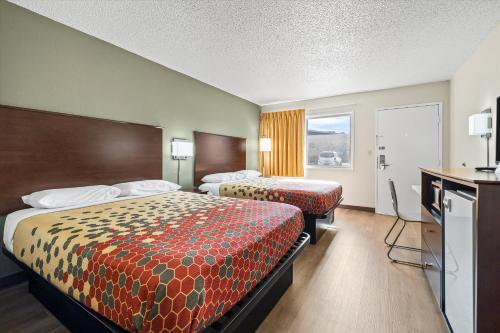 a hotel room with two beds and a television at Bend Inn & Suites in Bend