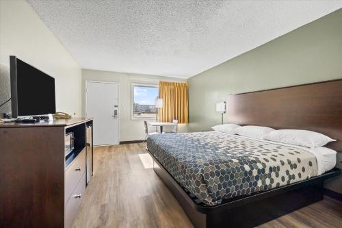 a hotel room with a bed and a flat screen tv at Bend Inn & Suites in Bend