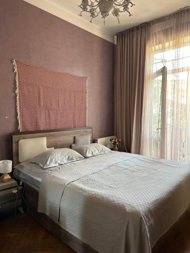 a bedroom with a large bed and a window at Bright apartment in front of Vake Square in Tbilisi City