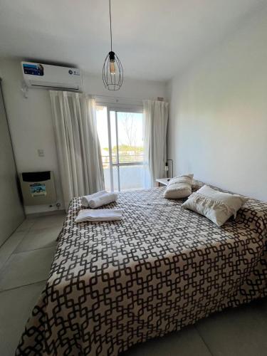 a bedroom with a large bed with a large window at Multi home in Concepción del Uruguay