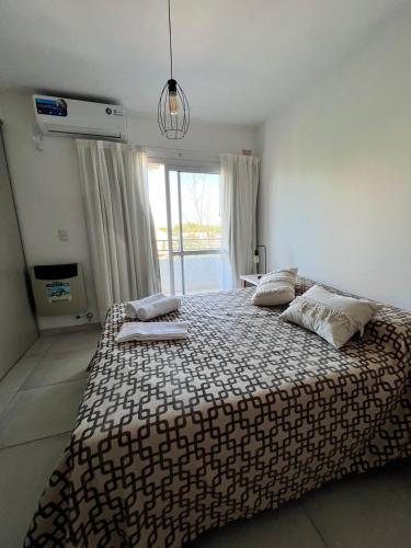 1 dormitorio con 1 cama grande y ventana grande en Multi home en Concepción del Uruguay