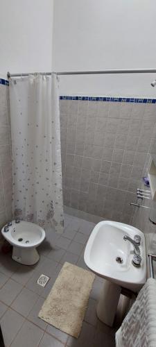 y baño con lavabo, aseo y ducha. en Departamento Cumbre Alta en Villa Dolores