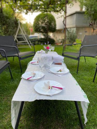 a white table with plates and glasses on it at Family Hotel "May" in Petrich