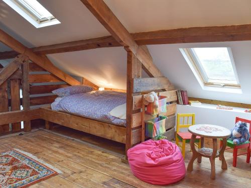 a attic bedroom with a bed and a table at Ravens Roost in Mathry