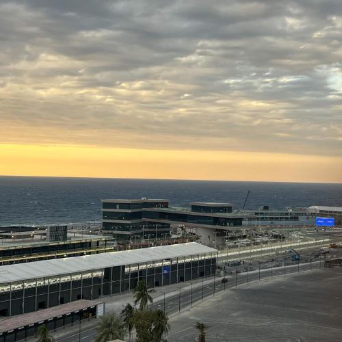 a view of a building with the ocean in the background at Almasarat Tower Sea View in Jeddah