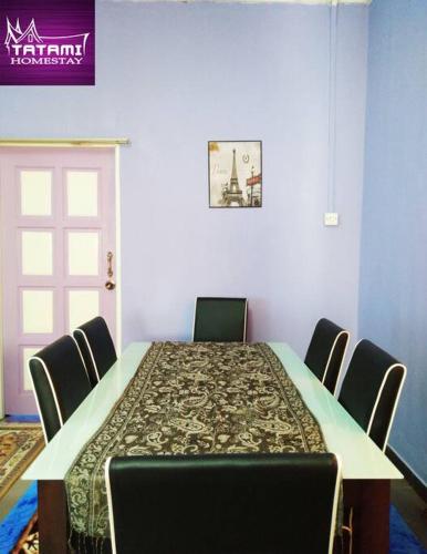 einen Esstisch mit Stühlen und einen langen Tisch mit einem Tisch in der Unterkunft Tatami Homestay UIA Gombak in Kuala Lumpur