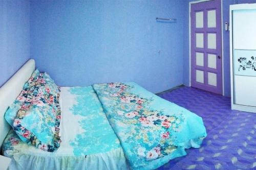 a blue room with a bed with flowers on it at Tatami Homestay UIA Gombak in Kuala Lumpur