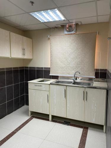 a kitchen with white cabinets and a sink in it at المهاجرين فرع الحزام in Medina