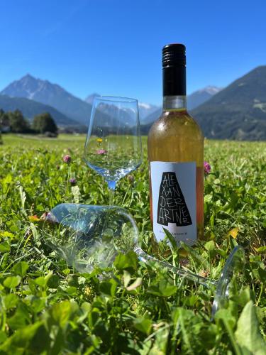 a bottle of wine and a glass in the grass at Hotel Restaurant Grünwalderhof in Innsbruck