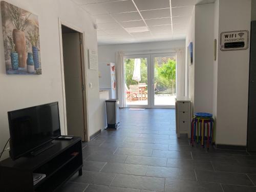 uma sala de estar com televisão e piso em azulejo em Rez-de-villa proche de la mer - Villa Temana em Saint-Cyr-sur-Mer