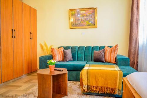 ein Wohnzimmer mit einem blauen Sofa und einem Tisch in der Unterkunft Vee’s Rustic Studio, Nakuru Town. in Nakuru