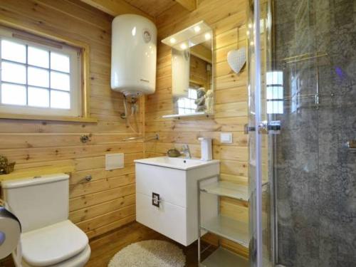 a wooden bathroom with a toilet and a shower at Słoneczna Osada Domki w górach na wyłączność in Kowary