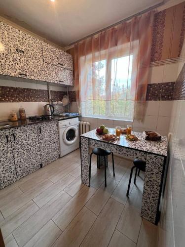 cocina con mesa y lavadora en LUX и комфорт, en Shymkent