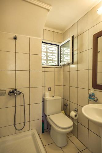 a bathroom with a toilet and a sink at Villa Olive by Seaside in Tsilivi