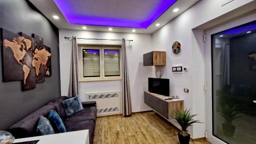 Una sala de estar con un sofá y un televisor. en Baby Suite, en Alberobello