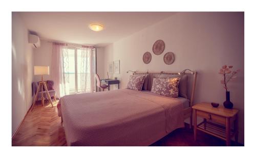 a bedroom with a bed and a table and a window at Condo with a breathtaking view in Dubrovnik