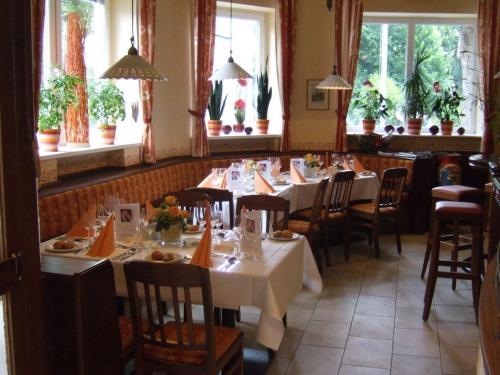 a dining room with tables and chairs and windows at Hotel-Garni Martinek in Baden