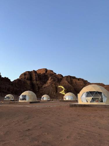 a group of tents in a desert with a mountain at Nara Wadi RUM Camp in Wadi Rum