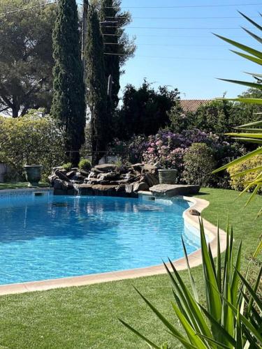 une grande piscine dans une cour avec de l'herbe verte dans l'établissement VILLA LA QUIETUDE, aux Issambres
